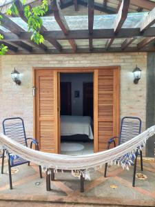 eine Hängematte auf einer Terrasse mit einem Schlafzimmer in der Unterkunft Casa Jabuticaba Refúgio e Hospedagem in São Miguel Arcanjo