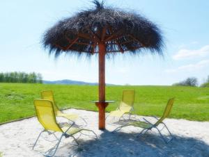 a table and four chairs under an umbrella at Niesamowita Dolina 