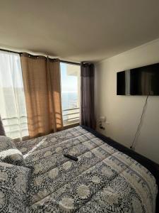 a bedroom with a bed with a view of the ocean at Reñaca departamento in Viña del Mar