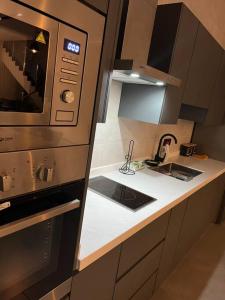 a kitchen with a sink and a microwave at شالية بيرليز الفندقي in Al Khobar