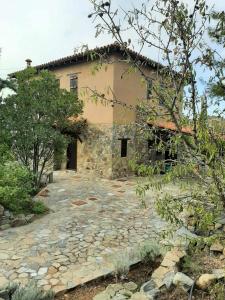 an old stone house with a stone driveway at FIKARDOU ALMOND PARK in Phikardhou