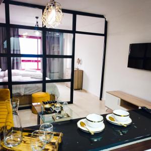 una sala de estar con una mesa con platos y vasos. en Moderne Appartement au plein Centre-Ville en Face Hilton, en Tánger
