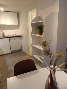 una cucina con tavolo e vaso di fiori di Cozy apartment close to downtown a Tromsø