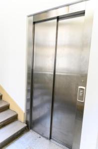 a metal elevator door in a building at Bp Central Home in Budapest