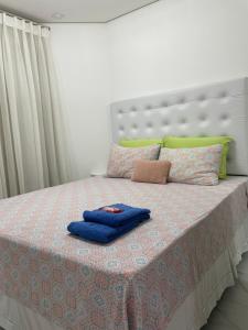 Una cama con una toalla azul encima. en Residencial Estanconfort Santos en Santos