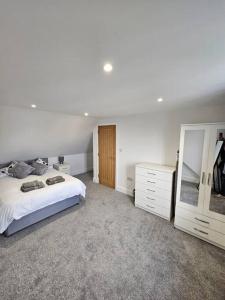 1 dormitorio con cama, tocador y espejo en Stunning 5 bed with free parking, en Aldershot