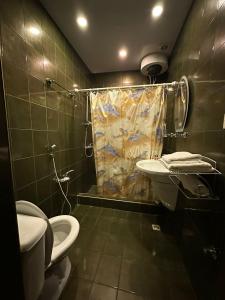 a bathroom with a shower and a toilet and a sink at Nur Hotel Sea View in Baku