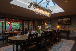 a dining room with tables and chairs and a chandelier at The Carpenters Arms in Tonbridge