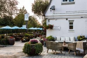 eine Terrasse mit Tischen, Stühlen und blauen Sonnenschirmen in der Unterkunft The Carpenters Arms in Tonbridge