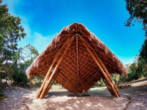 a large straw hut sitting on top of a field at Namastê Pousada e Camping in Cananéia