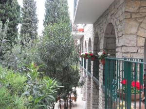 un bâtiment en pierre avec des plantes et des fleurs sur une clôture dans l'établissement Residence Gardasee 2, à Torri del Benaco