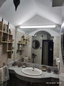 uma casa de banho com um lavatório e um espelho grande em Marrakech golf city em Marrakech