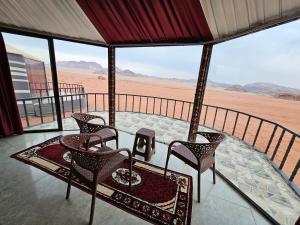 a room with chairs and a table in the desert at Wadi Rum Candles Camp in Wadi Rum