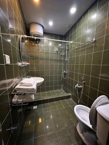a bathroom with a shower and a sink and a toilet at Nur Hotel Sea View in Baku