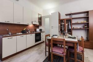 ミラノにあるMilanRentals - Baires Apartmentの白いキャビネットと木製テーブル付きのキッチン
