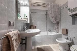 a bathroom with a sink and a tub and a toilet at MilanRentals - Baires Apartment in Milan