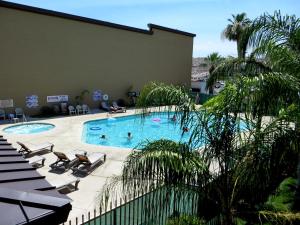 a swimming pool with chaise lounges and chairs in a hotel at The New Pioneer in Laughlin