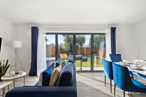 ein Wohnzimmer mit blauen Stühlen und einem Esstisch in der Unterkunft New Build 3 Bed House by AV Stays Short Lets Kent With Free Parking Ideal For Contractors in Sittingbourne