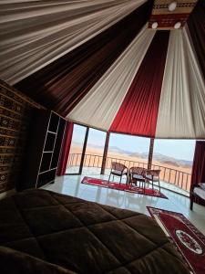 una camera con un letto e due sedie in una tenda di Wadi Rum Candles Camp a Wadi Rum