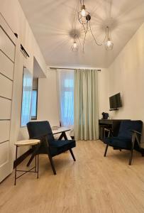 a living room with two chairs and a table at Apartamenty Chrobry in Gorzów Wielkopolski