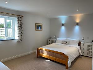 Un dormitorio con una cama grande y una ventana en Trefechan Wen Barn, en Llanwnda