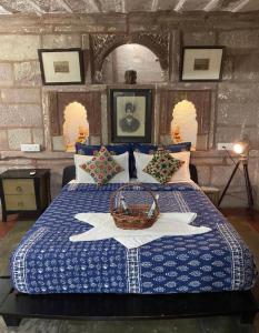 Banaji Heritage Haveli في جودبور: غرفة نوم بها سرير مع سلة عليه