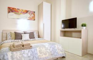 ミラノにあるMilanRentals - Firenze Apartmentのベッドルーム1室(ベッド1台、テレビ、タオル付)