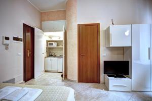 ミラノにあるMilanRentals - Lecco 11 Apartmentのベッドルーム(ベッド1台、テレビ、キッチン付)