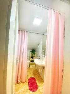 a bathroom with a shower with a pink shower curtain at Matejevic Apartments in Niš