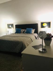 a bedroom with a bed with blue pillows and a table at Matejevic Apartments in Niš