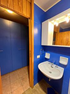 ein blaues Badezimmer mit einem Waschbecken und einem Spiegel in der Unterkunft Cervinia Studio in Breuil-Cervinia