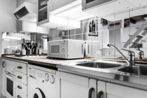 eine Küche mit einer Spüle und einer Mikrowelle in der Unterkunft MilanRentals - Ripa Apartment in Mailand
