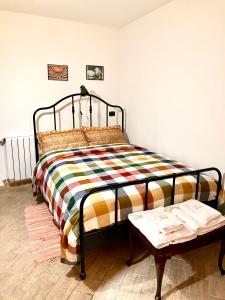 TorrettaにあるCasa Cipriano large beautiful Apt 120 m2 and small adorable Studio monolocale 23 m2のカラフルな毛布とテーブルが備わるベッド1台分です。
