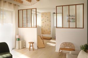 a living room with white walls and wooden floors at Chambres dans maison familiale à Plougastel Dalouas, à 20 minutes de Brest in Plougastel-Daoulas