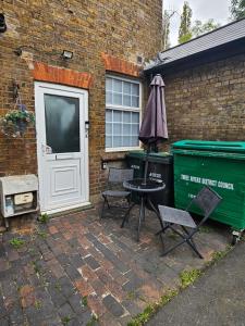 a patio with two chairs and a table and a trash can at Stylish 2 Bed Apt - Harry Potter/ Leavesden Studios/Watford/Hemel Hempstead - Families/Professionals & Contractors Welcome - Serviced Accomodation in Sarratt