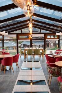 un restaurante con mesas y sillas y un techo con ventanas en Chalten Suites Hotel en El Chaltén