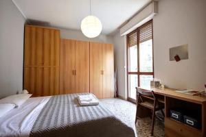 a bedroom with a bed and a desk and a desk at MilanRentals - Lotto Apartment in Milan
