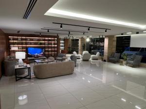 a lobby with couches and chairs and a flat screen tv at ليالي الشرقية لشقق المخدومة in Dammam