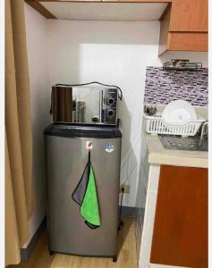 a small refrigerator with a microwave on top of it at One Bedroom Condo with fast wifi at Eastwood Lafayette tower Quezon city in Manila