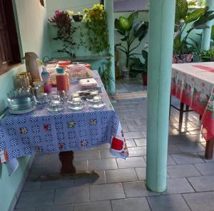 uma mesa com uma toalha de mesa azul com pratos em Pousada Cajueiro em Itaúnas