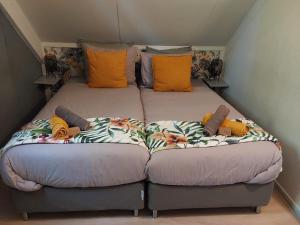 two beds sitting next to each other in a room at Rumah Senang Wellness met hottub en tuin in Ewijk