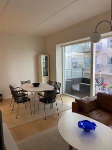 a living room with a couch and a table and chairs at Stjernepladsen in Aalborg