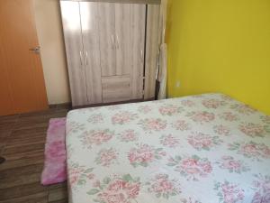 Un dormitorio con una cama con una sábana floral. en Casa de temporada, en Resende