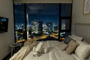 a bed in a room with a view of a city at Rooftop Jacuzzi - 18th Floor Apt City View in Mata de Palo