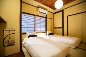 um quarto com duas camas e uma janela em 東雲庵/shinonomean em Quioto