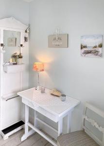 a white table with a lamp on it in a room at Villa Imme in Timmendorfer Strand