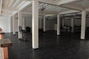una habitación vacía con columnas blancas, sillas y mesas en Finca Palma Roja, en Villavicencio