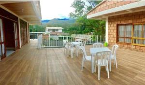 a patio with white chairs and tables on a deck at Finca Palma Roja in Villavicencio