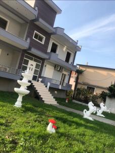 ein Haus mit Statuen im Gras davor in der Unterkunft Villa Castle View in Shkodra