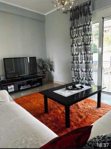 ein Wohnzimmer mit einem TV und einem Couchtisch in der Unterkunft Villa Castle View in Shkodra